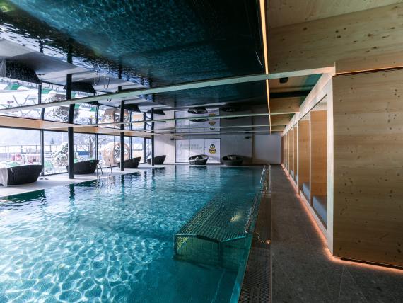 Indoor pool area at Familienresort Buchau with view of snowy outdoor scenery