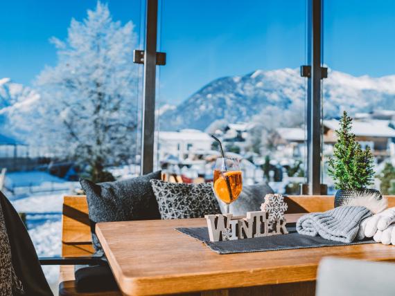 Familienresort Buchau: Tisch am Fenster mit Winterdeko und Bergblick