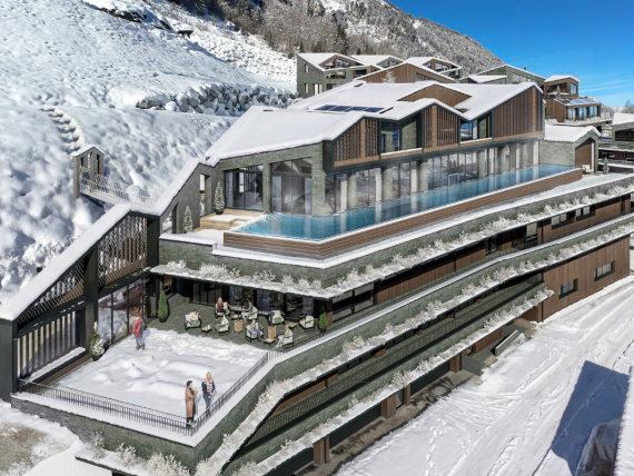 Moderne Architektur des Designer Motels Glockna in Fusch am Großglockner mit Infinity-Pool auf der Dachterrasse und schneebedeckten Alpen im Hintergrund.