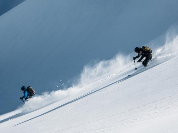 Zwei Skifahrer fahren am Hang mit Schnee bei Hotel Aurora