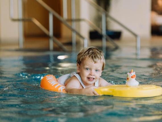 Kind im Pool mit Schwimmreifen im Familienresort Buchau