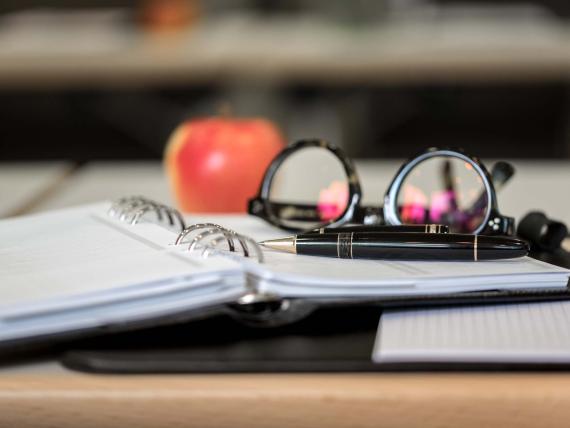 Land & Golf Hotel Stromberg Zimmer mit Lampe, Holztisch und rotem Sessel