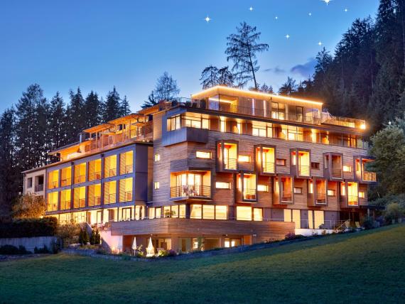 Naturhotel Die Waldruhe illuminato di sera nella foresta con cielo stellato