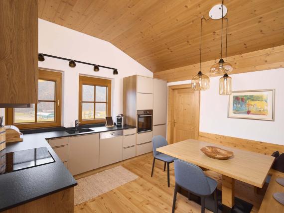 Moderne Küche im Hochfeldhof mit Holzdecke und Essbereich