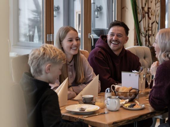 Familienfrühstück im Hotel Gassner mit Brötchen, Obst, Kaffee und Tee am Tisch