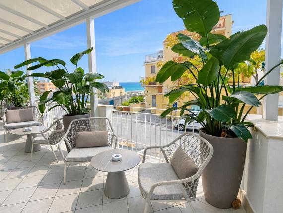 Terrazza con area salotto e piante al Regal Hotel Rimini con vista mare