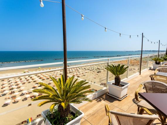 Balcone con fiori vista spiaggia con ombrelloni e mare