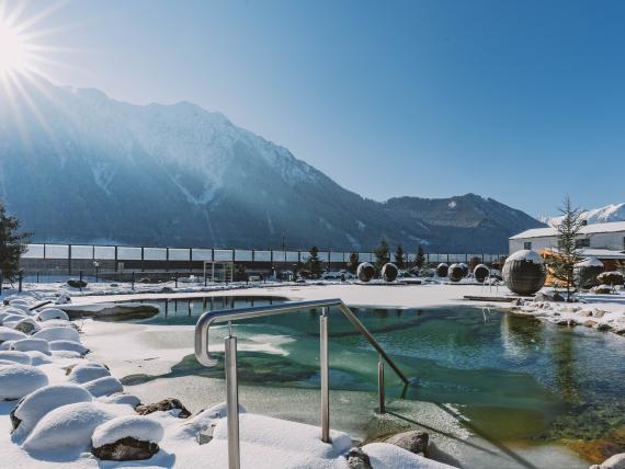 Winterlicher Außenpool mit Bergblick im Familienresort Buchau