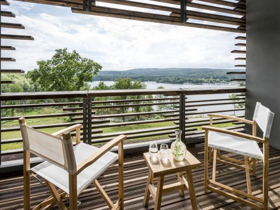 Balkon mit Stühlen und Seeblick im Seezeitlodge Hotel & Spa