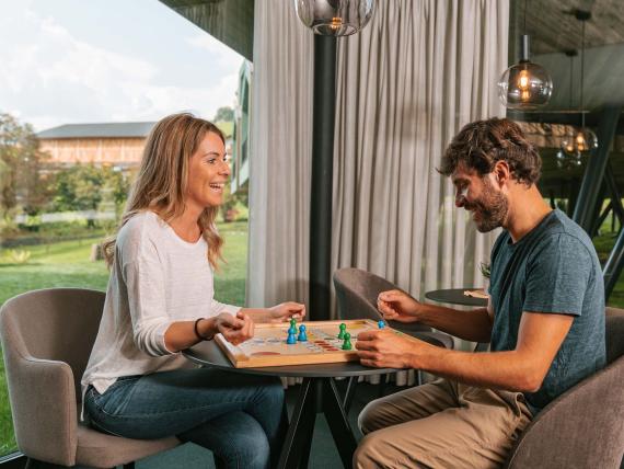 Paar spielt Brettspiel im Parc Hotel Florian mit Blick ins Grüne