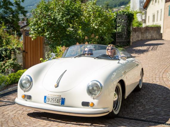 Weißer Oldtimer-Cabrio vor Castel Sallegg im sonnigen Pflasterweg