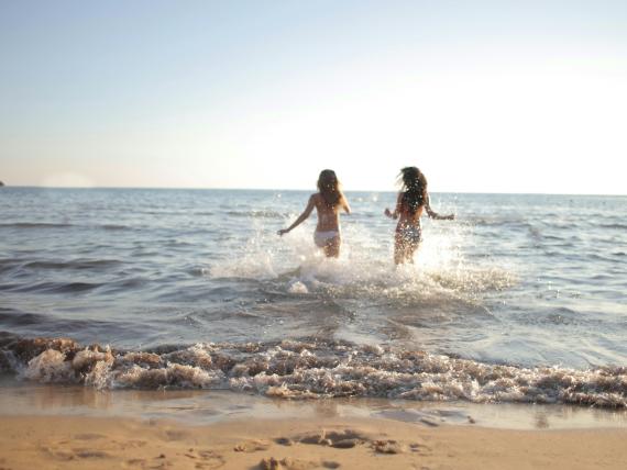 Le Rose Nuove Viserba due persone che giocano nel mare sulla spiaggia al tramonto