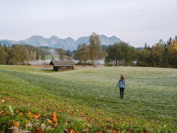 Person auf einer Wiese vor den Alpen beim Schlosshotel Kitzbühel