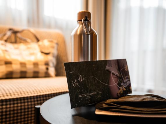 Detailaufnahme eines Zimmers im Hotel Gassner mit einer Grußkarte und einer Wasserflasche in Vordergrund