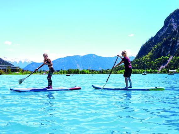 Zwei Personen paddeln auf Stand-Up-Paddle-Boards am Familienresort Buchau