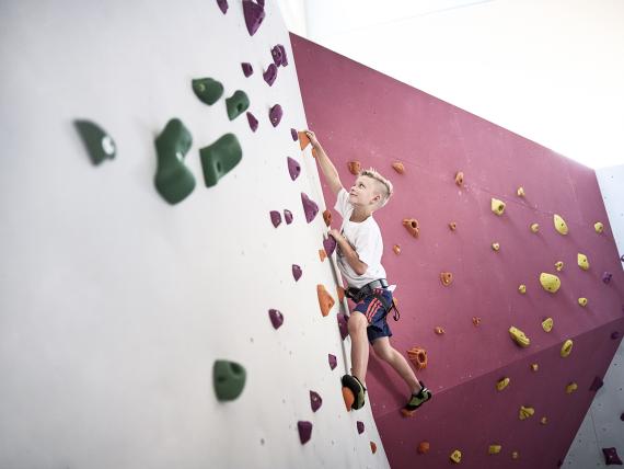 Kind klettert an der Kletterwand im Familienresort Buchau