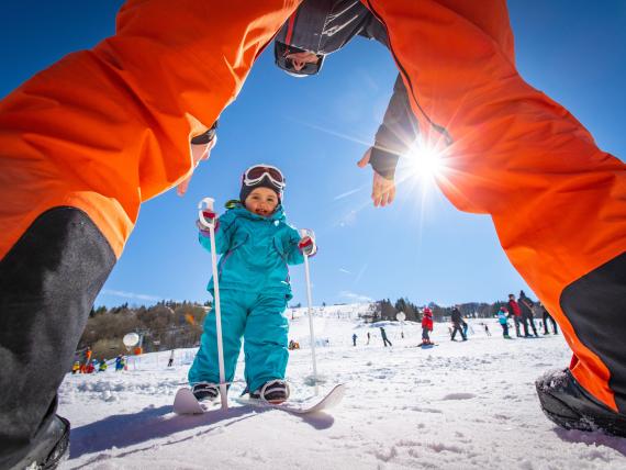 Elgus Nature Retreat: Ein Kind übt Skifahren, eingerahmt von einem Elternteil im Schnee