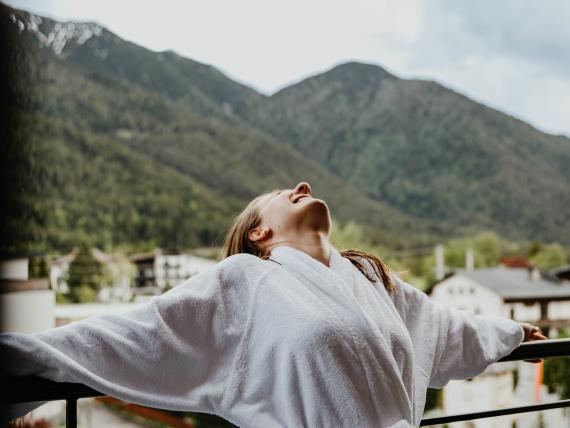 Person liegt in Blumenwiese vor Berg bei Post Seefeld - Wellnesshotel Tirol