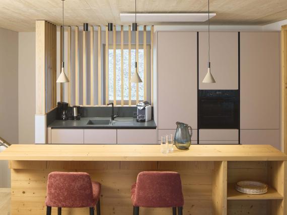 Moderne Küche im Hochfeldhof mit Holztheke und roten Stühlen