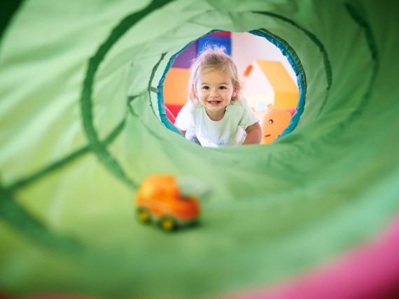 Kind spielt in einem Tunnel im Familienresort Buchau
