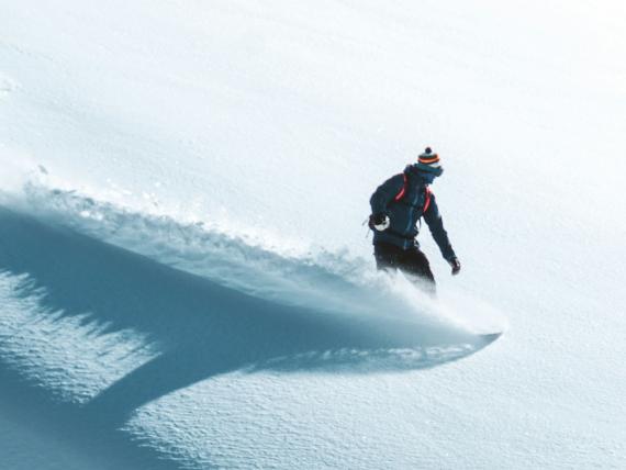 Snowboarder fährt Pulverschnee im Sporthotel Silvretta Montafon Gaschurn