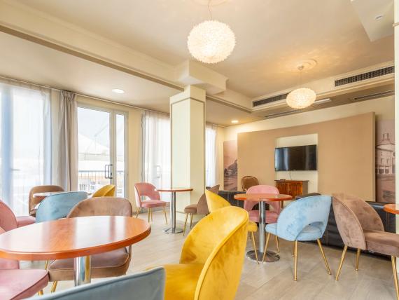 Sala luminosa e moderna con sedie colorate a Le Rose Nuove Viserba