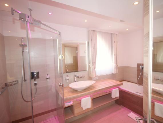 Moderne Badezimmer im Hotel Bercher mit Dusche, Badewanne und Waschbecken
