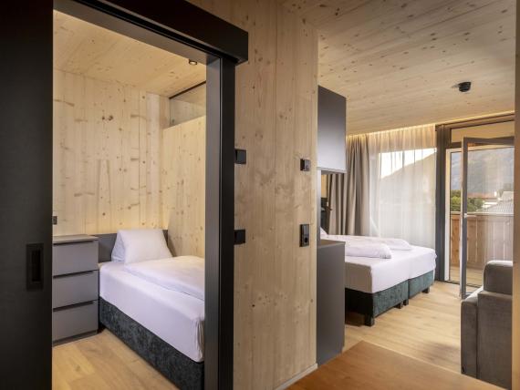 Modernes Hotelzimmer mit hellen Holzwänden im Der Dolomitenhof ***S