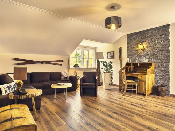 Gemütlicher Wohnbereich im Hammerhof Bodenmais mit Holzfußboden und rustikaler Dekoration