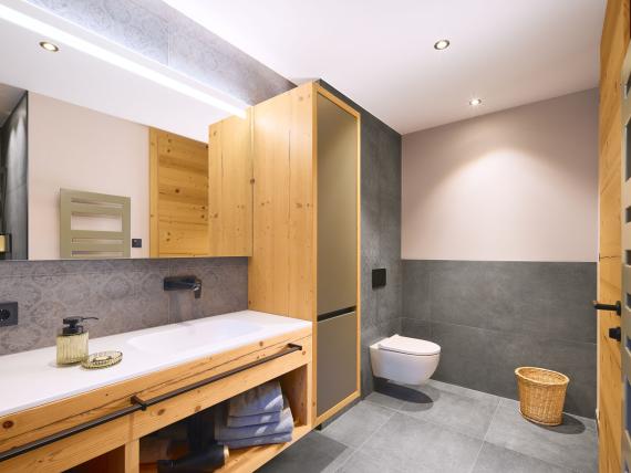 Modernes Badezimmer im Hochfeldhof mit Holzschränken und grauen Fliesen