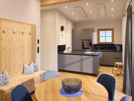 Moderne Küche und Essbereich im Hochfeldhof mit Holzmöbeln und grauen Schränken