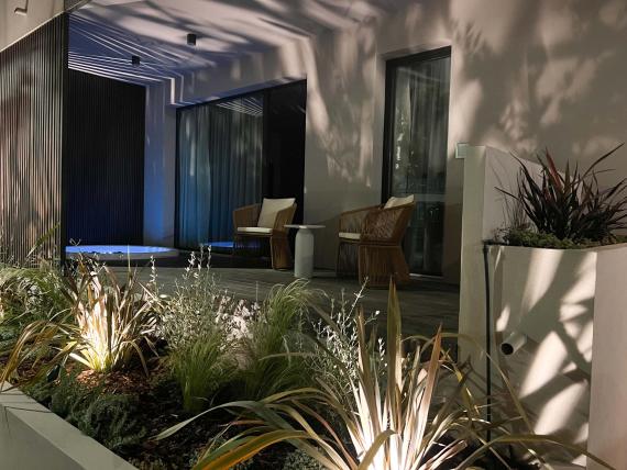 Terrazza illuminata di Evangelisti Palace Suite & Apartaments con sedie e piante