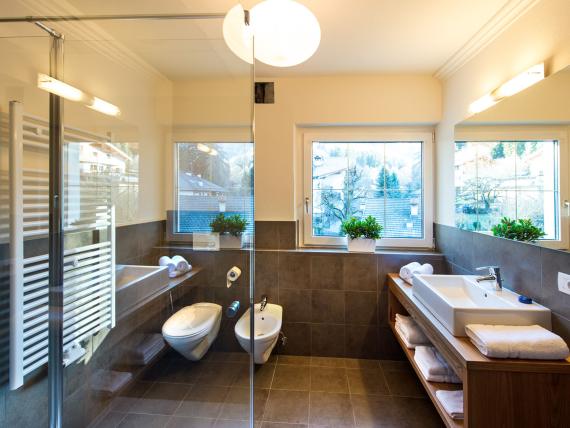 Modernes Badezimmer im Parc Hotel Florian mit Dusche und Fensterblick