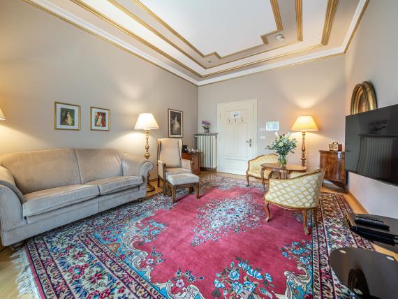 Elegant living room at Hotel Adria with comfortable seating and oriental carpet