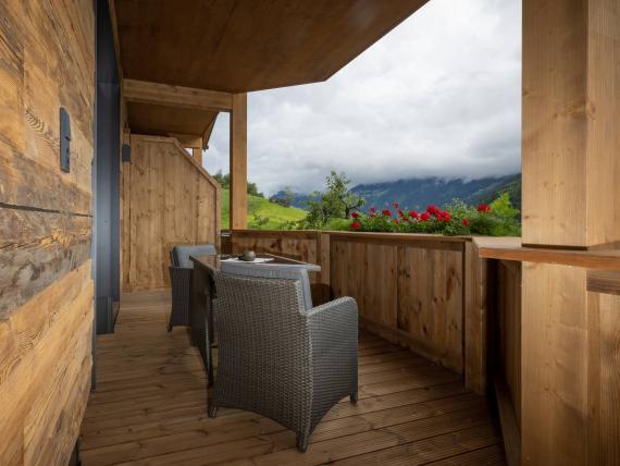 Balkon mit Holzverkleidung und Stühlen im Hochfeldhof mit Bergblick
