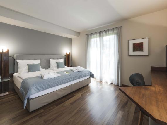 Modernes Hotelzimmer im Hotel Mignon Meran Park & Spa mit Doppelbett und Parkettboden