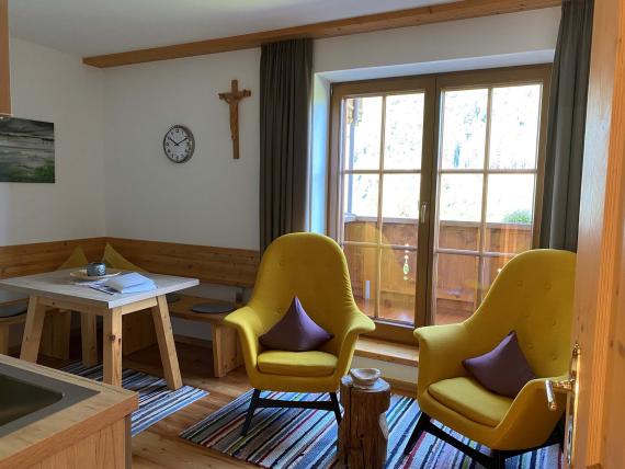 Gemütliche Sitzecke mit gelben Sesseln und Balkon im Hochfeldhof