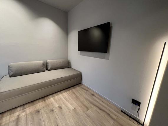 Area soggiorno moderna con divano e TV in Evangelisti Palace Suite & Apartaments