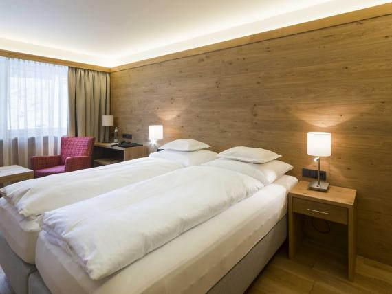Hotel Panorama Doppelzimmer mit Holzwand, zwei Betten und großem Fenster