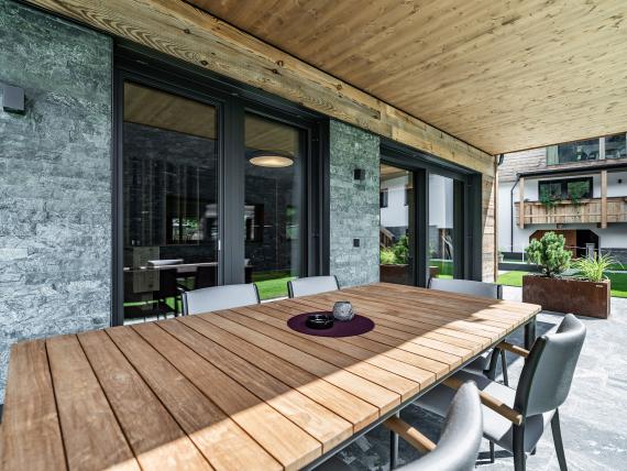 Moderner Außenbereich mit Holztisch und Stühlen am Hochfeldhof