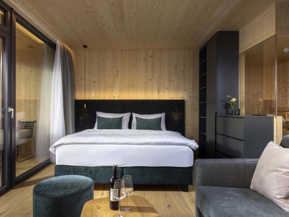 Der Dolomitenhof ***S moderne Holzschlafzimmer mit Bett und Sitzbereich