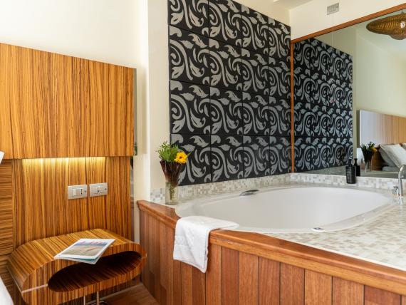 Vasca idromassaggio e sedia in legno nella camera del Bibione Palace Hotel