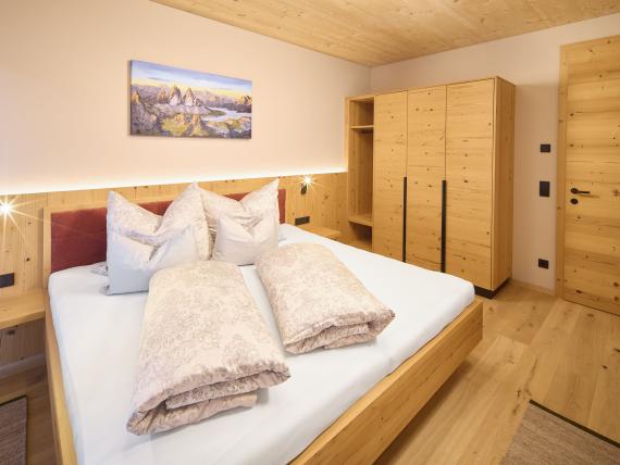 Gemütliches Schlafzimmer im Hochfeldhof mit Holzmöbeln und Deckenleuchte