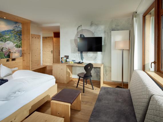 Gemütliches Zimmer im Naturhotel Die Waldruhe mit Holzinterieur und großem Fenster