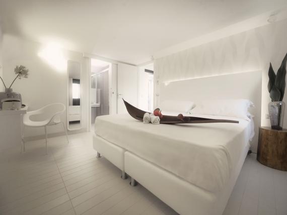 Camera da letto moderna e luminosa al Q Hotel con arredi bianchi