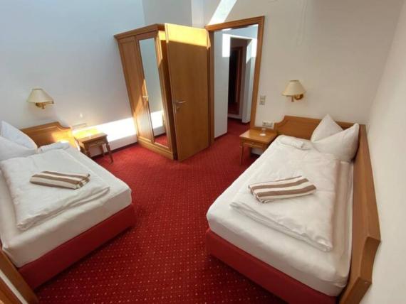 Hotel Moarhof Zimmer mit zwei Einzelbetten und rotem Teppich