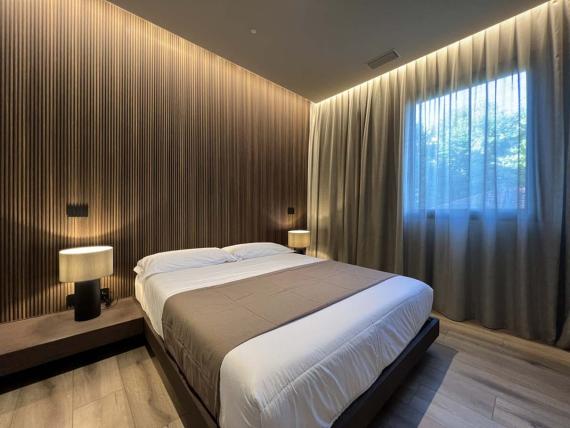 Camera da letto con letto matrimoniale e illuminazione indiretta in Evangelisti Palace Suite & Apartments