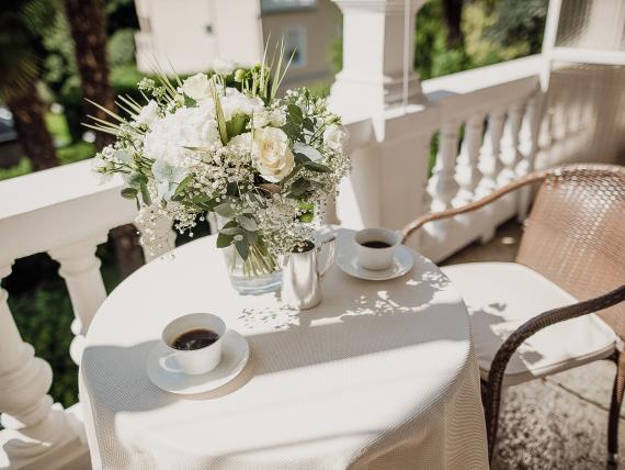 Balcony table with flowers and coffee at Hotel Adria
