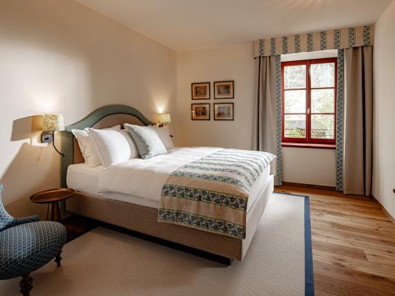 Gemütliches Schlafzimmer im Castel Sallegg mit Doppelbett, Sessel und Fenster