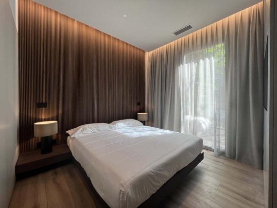 Camera da letto elegante in Evangelisti Palace Suite & Apartments con parete in legno e lampade